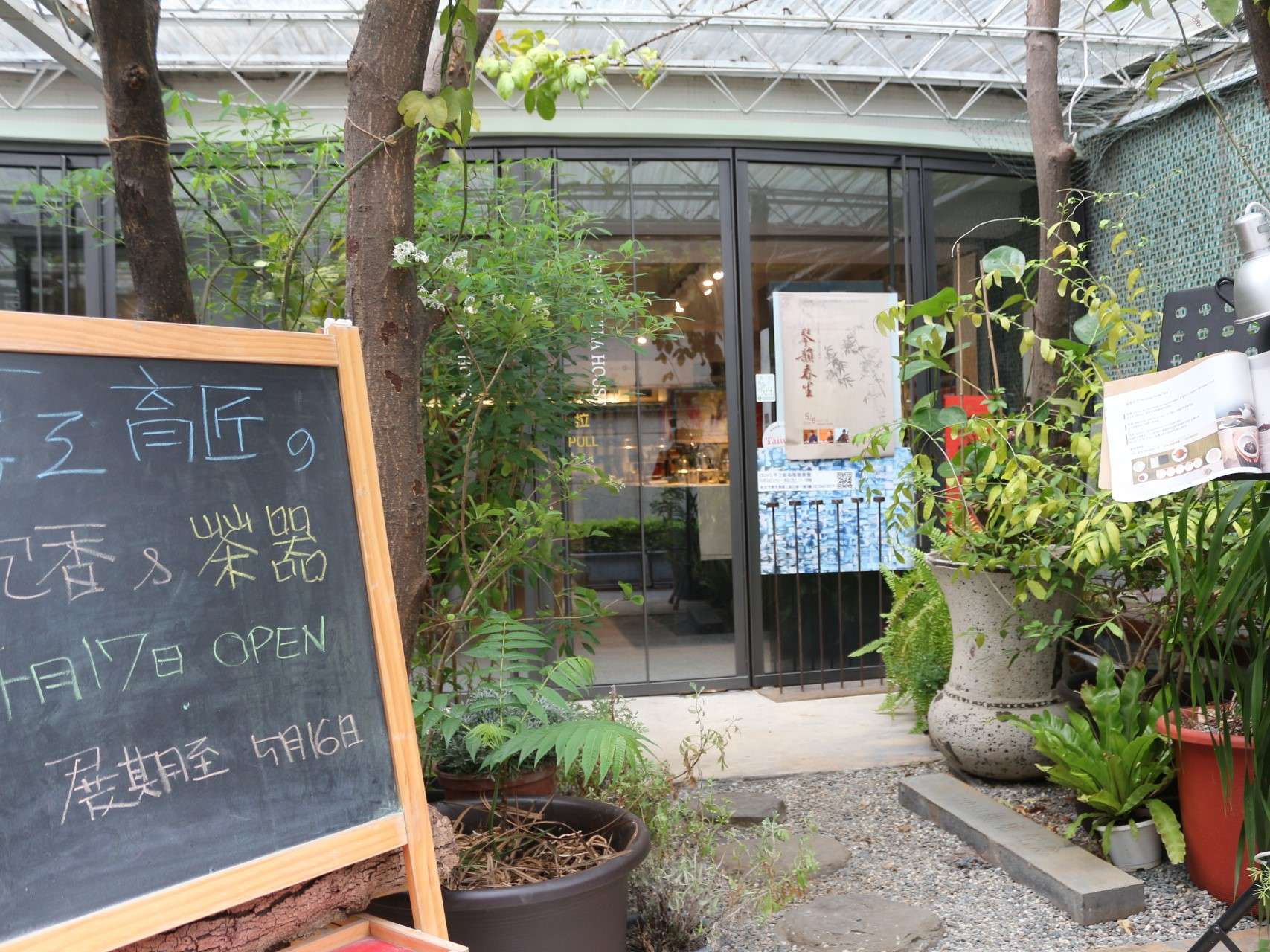串門子茶館の茶席と台湾茶の茶器が並ぶ落ち着いた店内