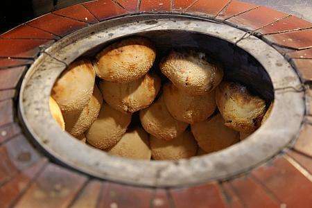 特製の窯で炭火焼きにされる胡椒餅の生地