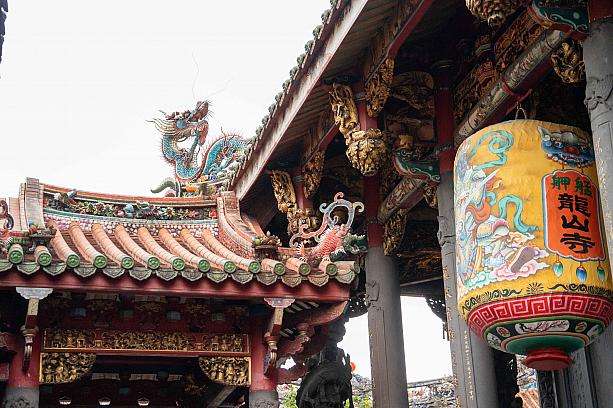 龍山寺の境内。多くの参拝者がお香を手に真剣に祈りを捧げている