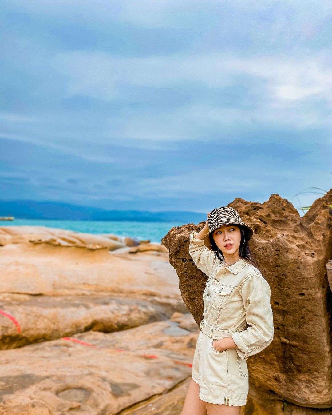 野柳地質公園のクイーンズヘッド岩。海岸を背景に立つ