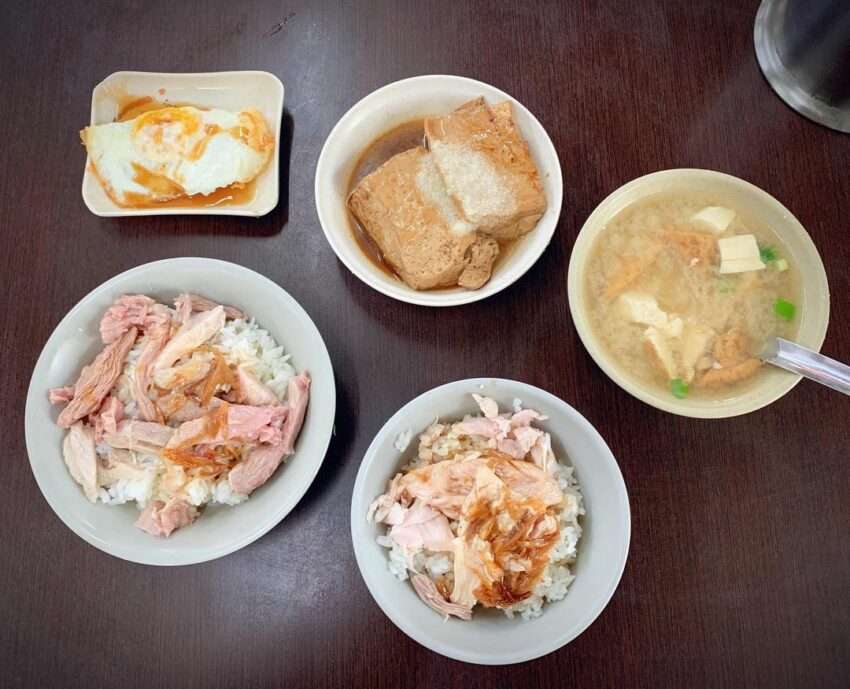 嘉義人火雞肉飯のテーブル。スライスした鶏肉を乗せたご飯と冷菜の小皿が並んでいる