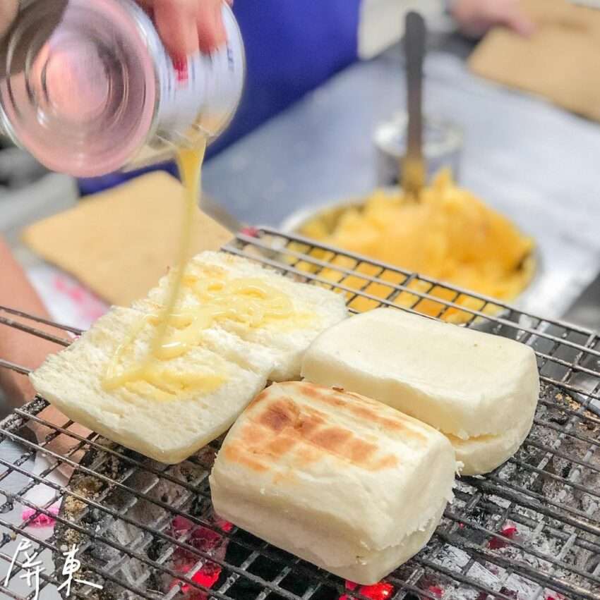 佳吉碳烤饅頭。炭焼きで外皮に焦げ目がつき、肉・ハム・目玉焼きを挟んだボリューム満点の朝食