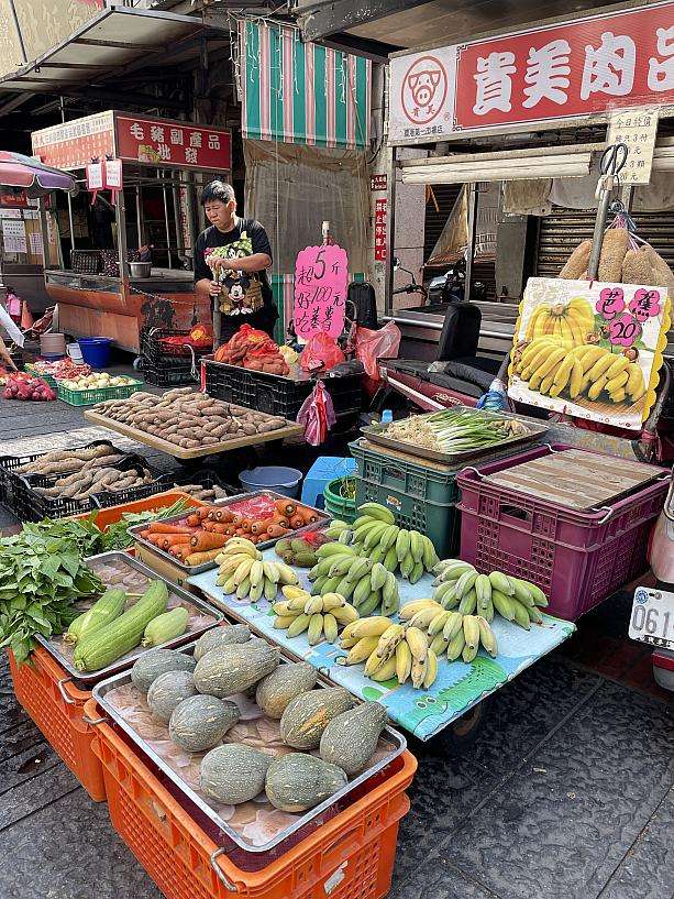 市場外周の野菜・果物・雑貨を扱う店舗が並ぶ様子