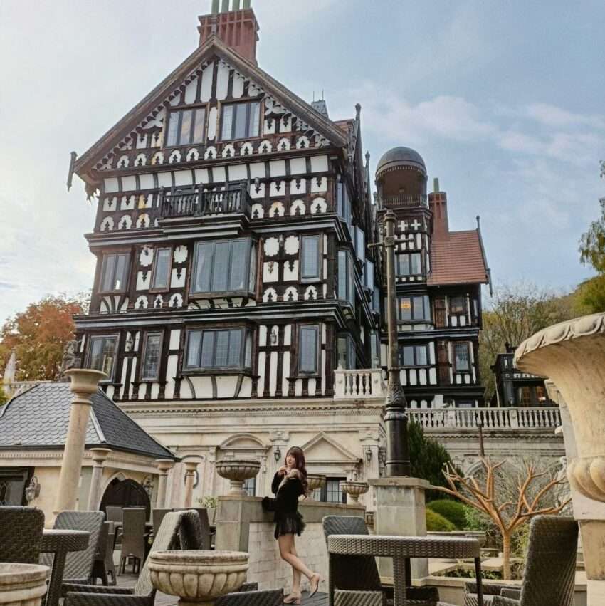 オールド・イングランド・マナーの外観。チューダー様式の英国建築が清境の緑の山を背景に立つ