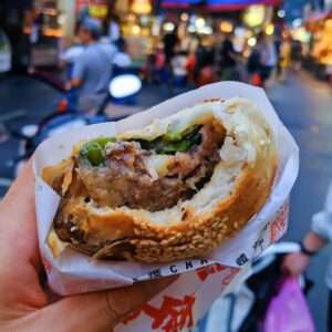 福州世祖胡椒餅が焼き上がった様子。表面に金色のごまがついており、炭火の窯の壁に複数の餅が貼り付けられている