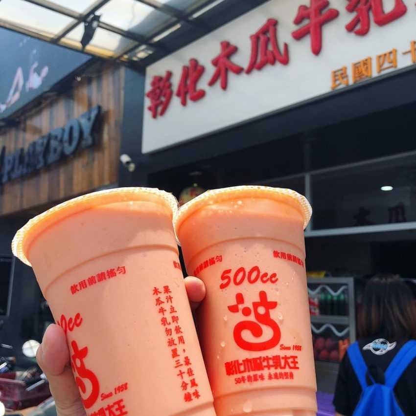 彰化木瓜牛乳大王の濃厚なオレンジ色のパパイヤミルクが透明カップに入っている