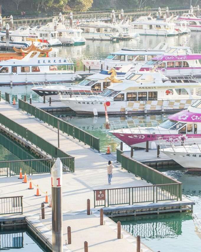 水社碼頭の木製桟橋と湖景。旅行者が遊覧船を待っている