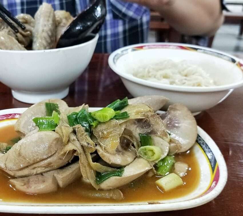 環記麻油雞の麻油鶏スープ。鶏肉の塊が濃い色のごま油スープに浮かんでいる