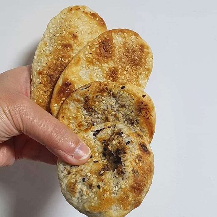 焼きたての焼餅。表面がきつね色に焼き上がり、ごまが散りばめられている