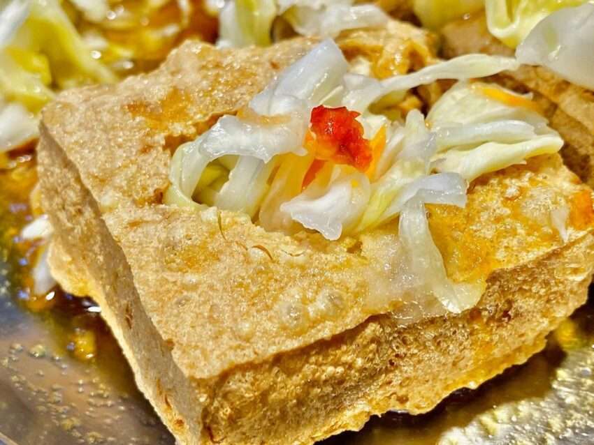 名彭下港臭豆腐。金色に揚がった臭豆腐に自家製酸菜とタレが添えられている