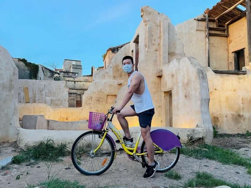 K Bike（金門公共自転車）に乗る旅客。緑の木陰が続く小道を走っている