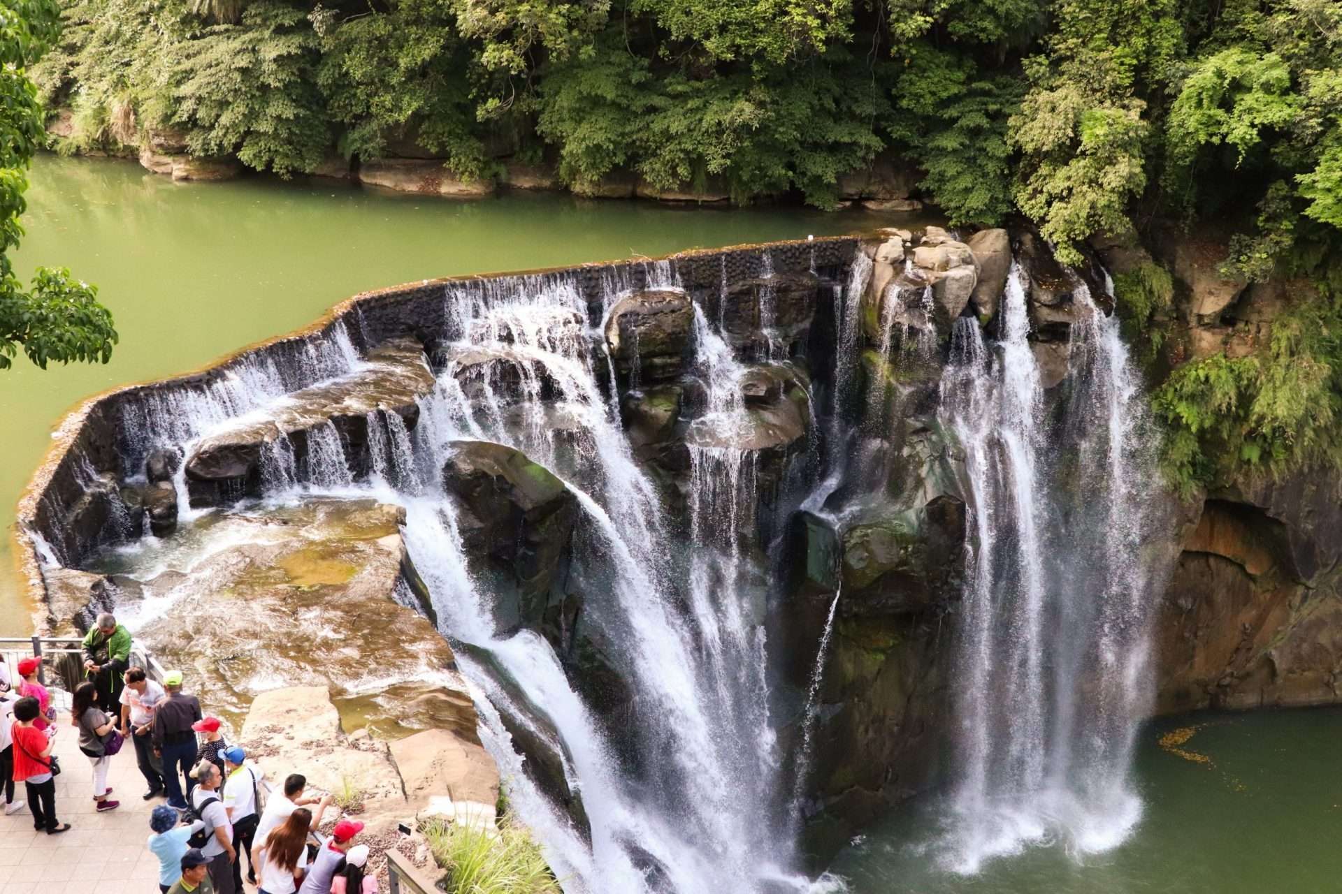 幅広い水のカーテンが轟音とともに落下する十分瀑布。水しぶきが辺りに霧のように広がる