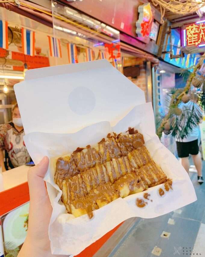 泰象香蕉煎餅の現作りバナナパンケーキにソースを塗っている様子