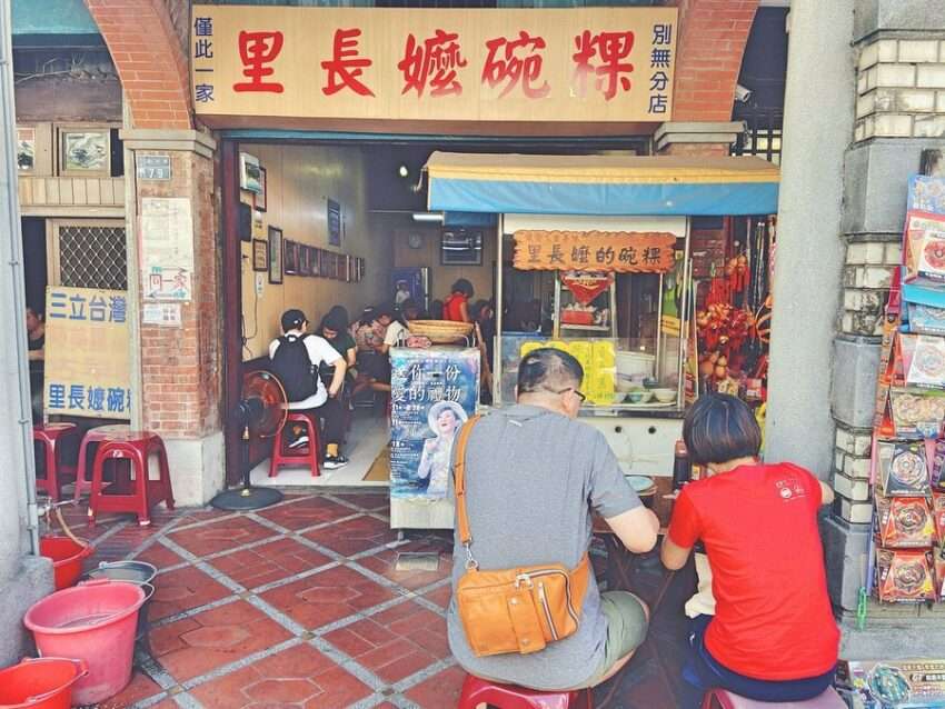 里長嬤碗粿の店頭。テーブルには伝統的な碗粿と貢丸スープが並ぶ