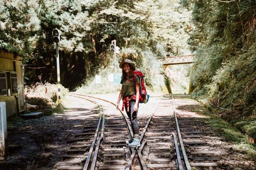 眠月線トレイルの奥深く、廃線の線路が霧に包まれた針葉樹林の中へ続いている