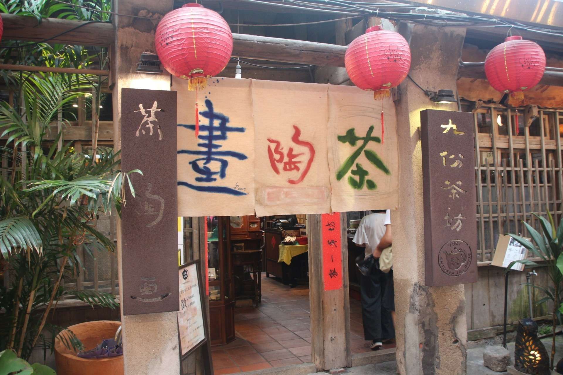 九份茶坊の店内。茶席に陶芸作品と書画が展示され、芸術的な雰囲気が漂う
