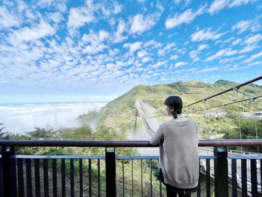 吊り橋の側面から山の谷と雲霧を望む景色