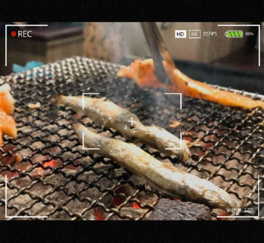 燒肉眾精緻炭火燒肉の和牛スライスが炭火で焼かれている。霜降りが豊かで香ばしい