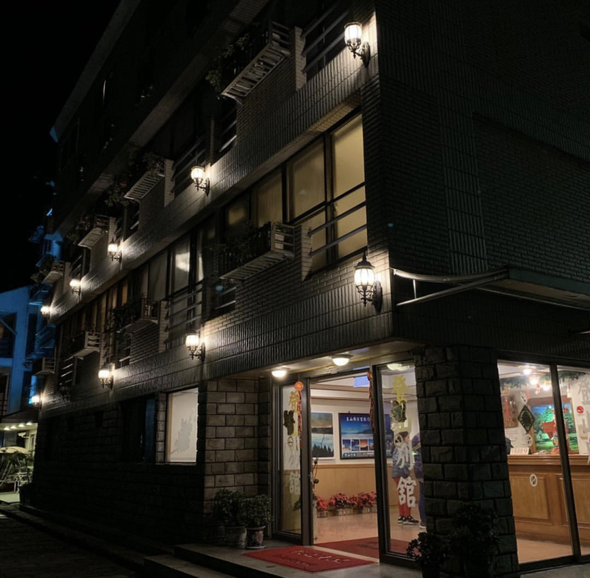 登山別館の客室。シンプルな内装と窓の外の自然の景色