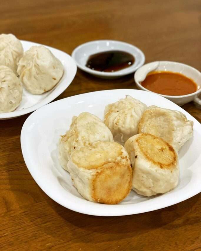 鍾記原上海生煎包。底面がきつね色に焼かれ、表面にごまが散らされた焼き小籠包