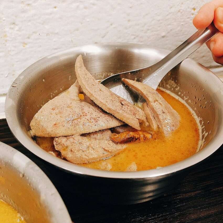 阿男麻油雞のごま油チキンスープ。艶やかな油が浮かぶ濃厚なスープ