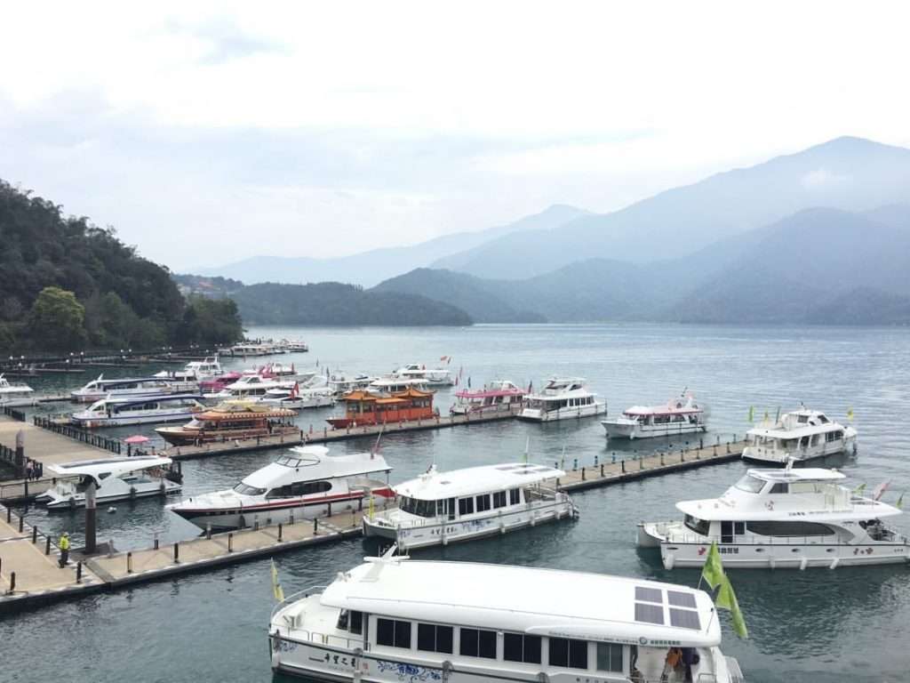 日月潭の埠頭に停泊するさまざまな色の遊覧船。各船会社の外観の違いがわかる