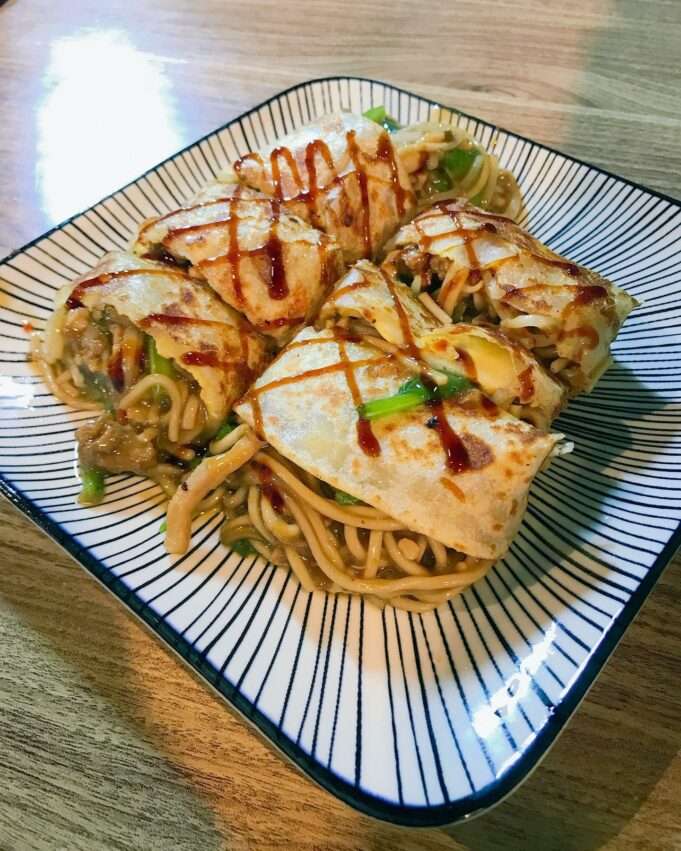 鴻記蔥餅捲のネギ巻き餅。薄い生地にネギが巻かれており、卵入りバージョンも選べる