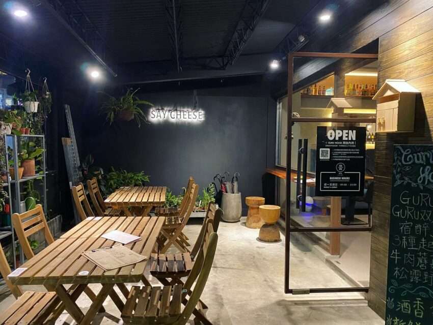 GURU HOUSEのアメリカンスタイルの料理がプレートに盛られ、ドリンクが添えられている