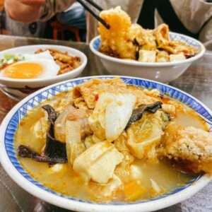 林聰明砂鍋魚頭のセット全体像。多彩な小菜が添えられている