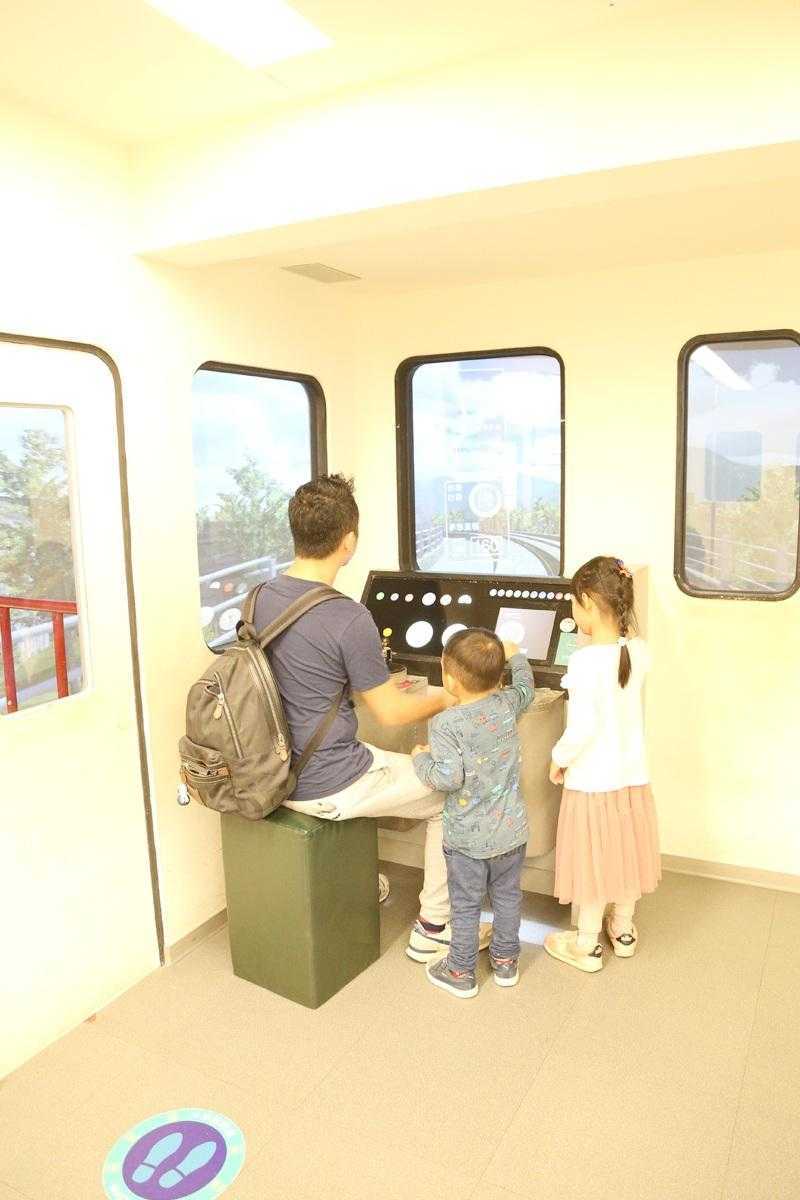 交通ドリームホールのVR列車シミュレーター運転席。参観者が操縦桿を握っている