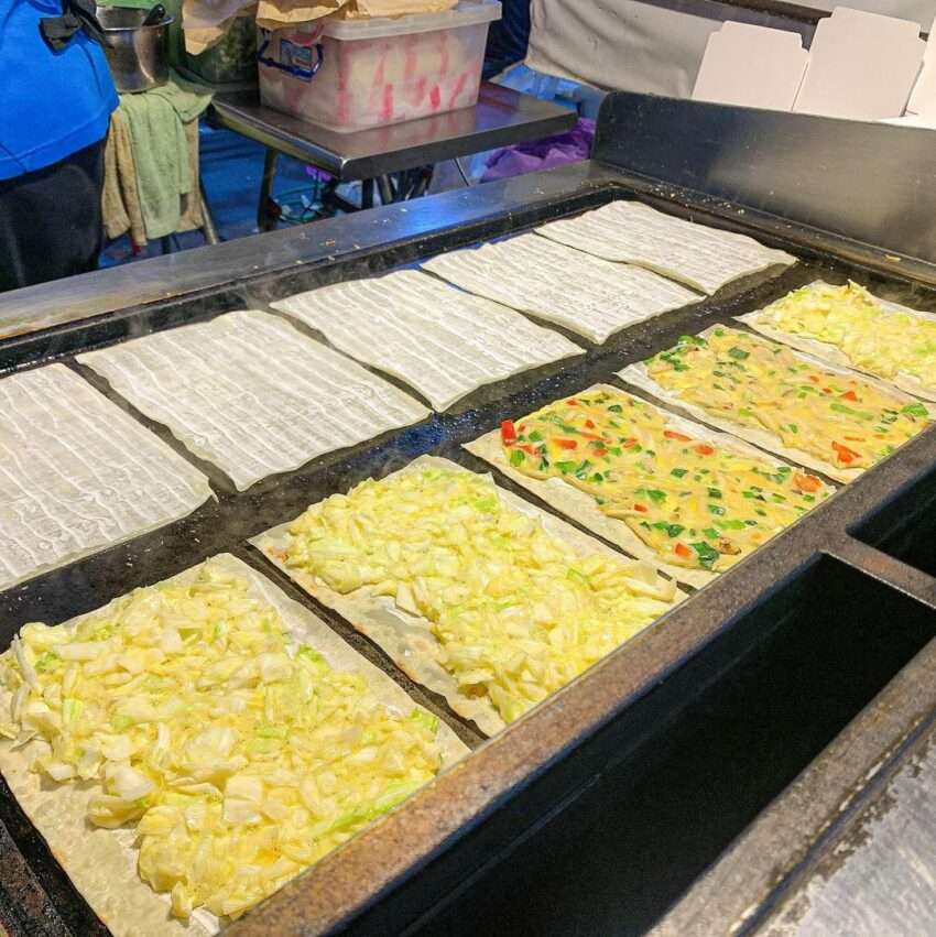 小旺仔宜蘭蛋餅。巻かれた餅皮が金色に焼け、タレが添えられている