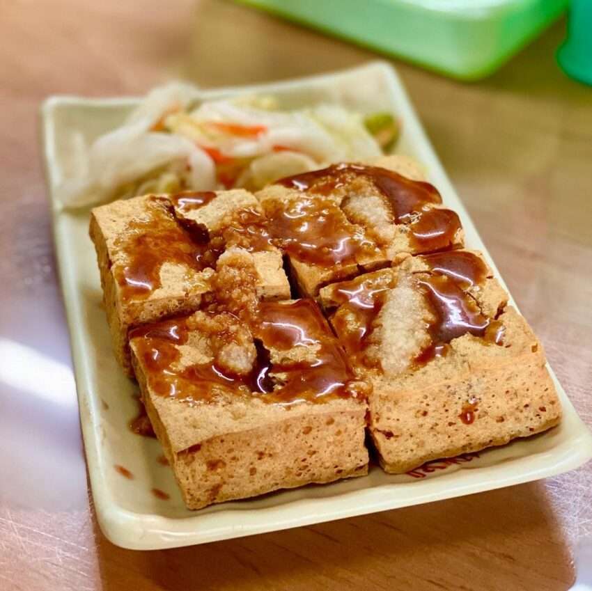 財記臭豆腐のチーズ臭豆腐バーガー。サクサクの生地に包まれた臭豆腐とそぼろが金色に輝いている