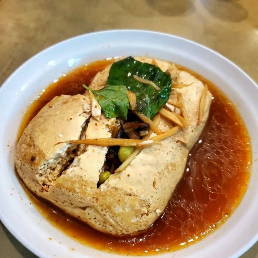 臭老闆現蒸臭豆腐の完成品。豆腐の表面がなめらかで、酸菜とタレが添えられている