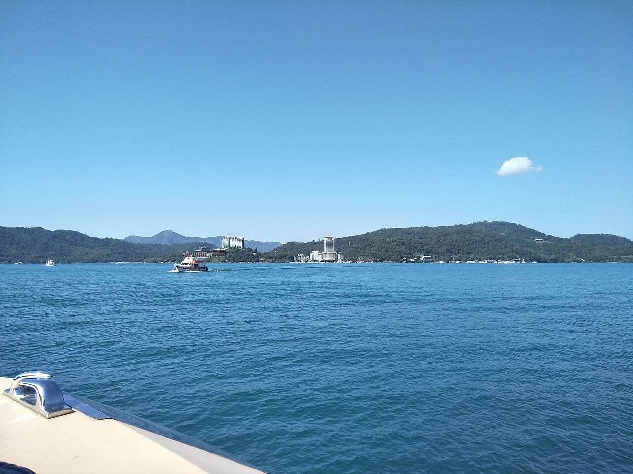 日月潭の湖面が穏やかで、遠くの山の倒影がくっきりと映る