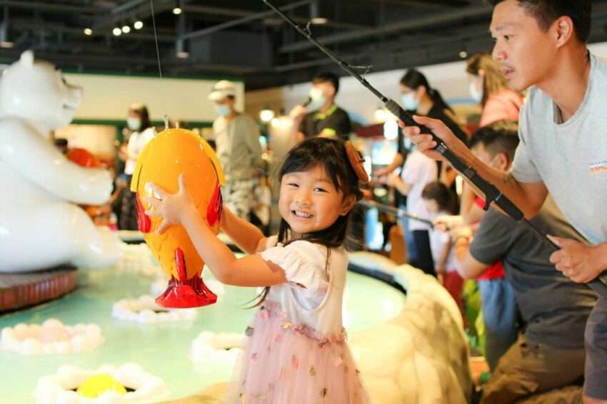 寶熊漁樂碼頭のインタラクティブ体験エリアで釣りゲームに挑戦する子ども