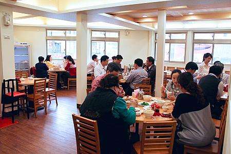 ランチタイムに訪れるスーツ姿のビジネスパーソンたち。黄龍荘の地元人気を示す日常の光景