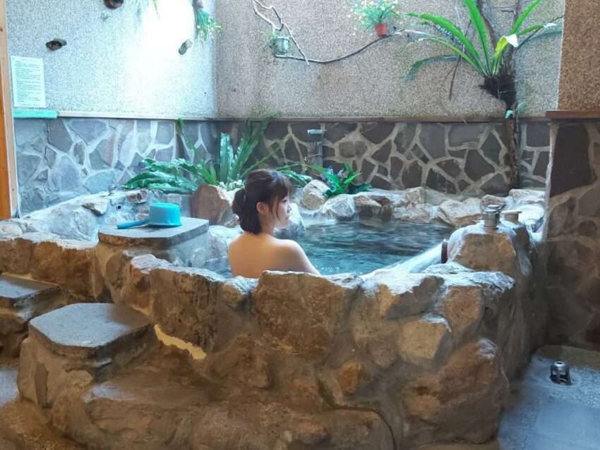 四季温泉会館の屋外温泉浴槽。日本式の造りと周囲の山林が調和している