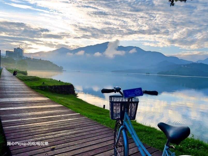 日月潭の水社ダム路線でサイクリングを楽しむ旅行者。ダム上を自転車で走る様子