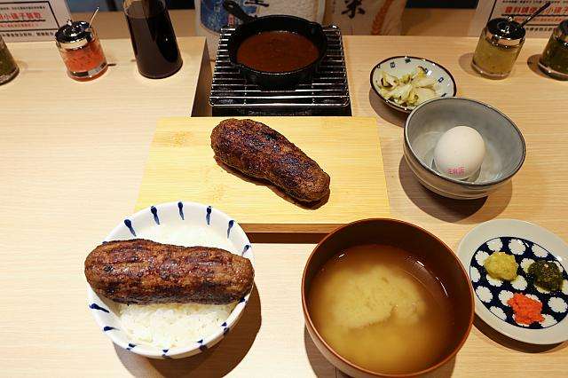 ハンバーグ嘉の定食。ご飯の上に置かれた炭火焼ハンバーグと薬味