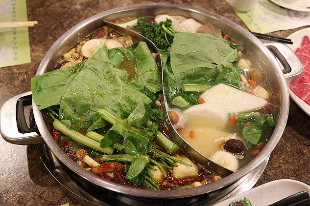 青菜や豆腐を入れて煮込む天香回味の二色鍋
