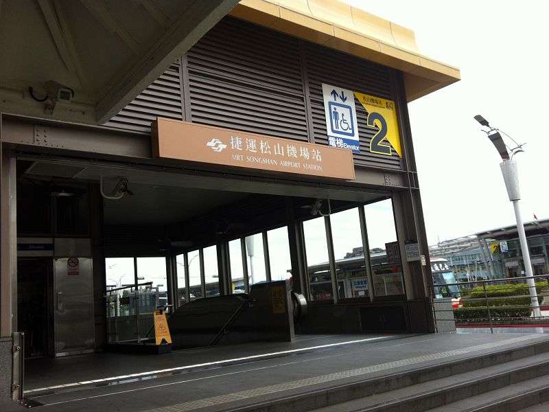 台北MRT松山機場駅の2番出口外観。案内板と通路入口が見える