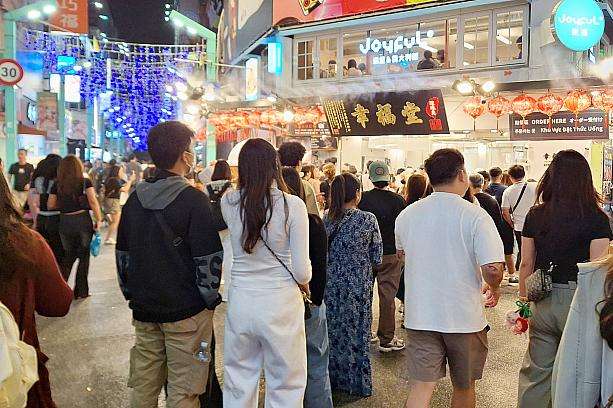 夜市の屋台街で買い物客が行き交う混雑した風景