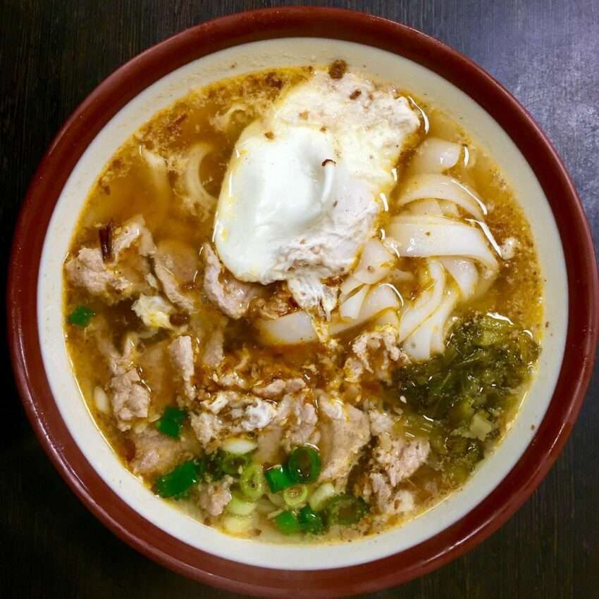忠貞米甘の米干。酸菜・半熟卵・バイ族唐辛子粉が添えられている