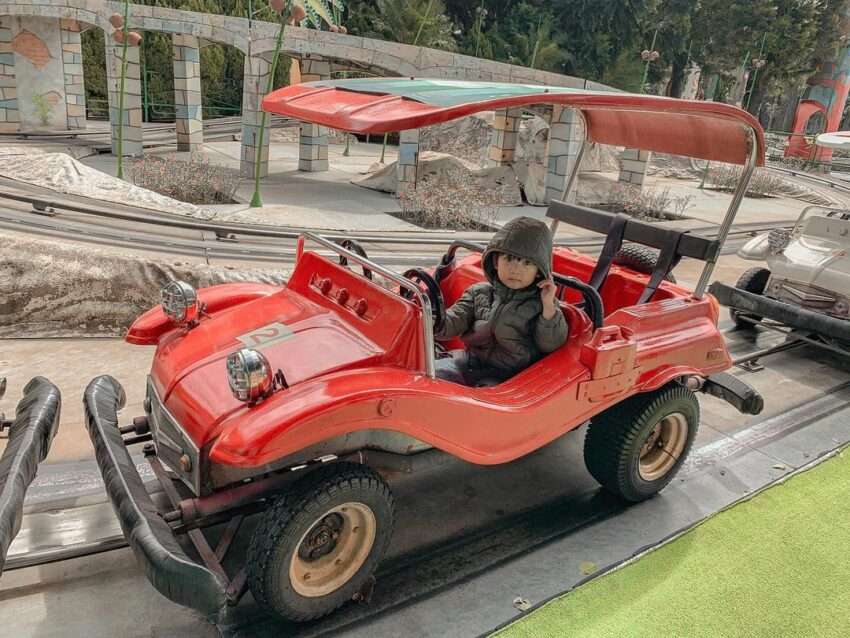子ども用ジープカー。子どもが自分でハンドルを操作しながらレールを走行する