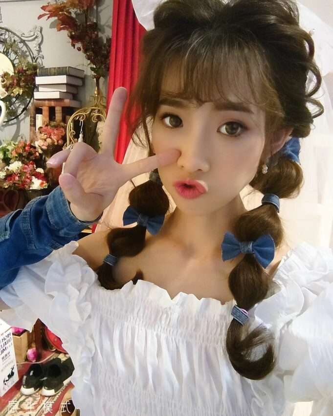 ほっぺをつまんでおどける女性の半身写真