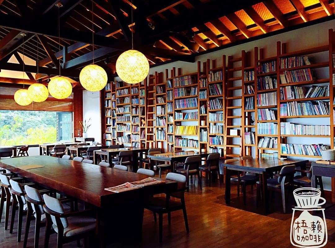 出霧溫泉會館の屋上書斎。天井まで届く本棚と約180度のガラス窓から山の景色が広がる