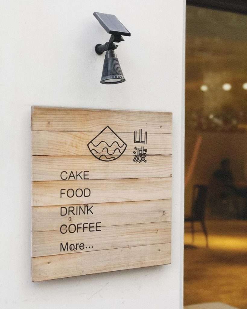 山波 Simple の店内。暖色系の木製テーブルと椅子が並び、精緻なスイーツが置かれている