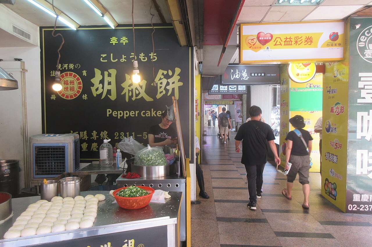 胡椒餅を売る屋台と行き交う客でにぎわう台北の商店街